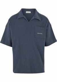 Marineblå bomullspolo med V-hals, korte ermer og brystlomme. Har subtil tekstur og brodert logo på lommen.