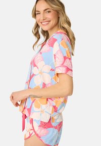 Korte mouwen, slaapset met bloemenprint in pastelkleuren, lichte stof en een strikaccent op de shorts voor een verstelbare pasvorm.