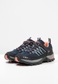 Morskie wodoodporne buty trekkingowe z czarnymi akcentami, z teksturowanym wzorem, jasnoniebieskimi sznurowadłami oraz różowymi detalami na podeszwach i obcasach.