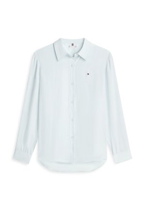 Chemise bleu clair à manches longues avec col et petit logo brodé sur le côté gauche de la poitrine, présentée sur fond blanc.