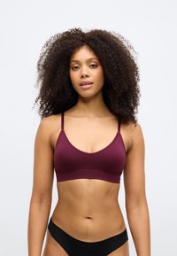 Bralette em tecido elástico bordô com alças finas e ajustáveis e um acabamento suave. Apresenta um design simples e uma silhueta sem costuras.