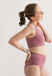 Drahtloser BH und hochgeschnittene Unterwäsche in Mauve, aus glattem, dehnbarem Stoff gefertigt. Verfügt über ein unterstützendes Band und minimale Nähte.