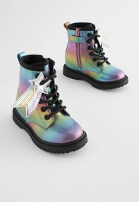 Iridescent ankelstøvler med sorte snørebånd, en lynlås på siden og en dekorativ sølvstjerne. Har en struktureret, skinnende overflade.