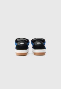Melni un zili zamšādas Vans sporta apavi ar baltām zolēm un gumijas ārējām zolēm. Iezīmēts ar mīksto apkakli un logotipu uz papēža.