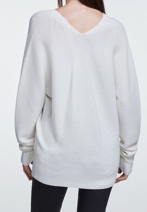 Maglione bianco a maglia con scollatura a V e vestibilità ampia, caratterizzato da polsini a costine e tessuto testurizzato, che scende oltre i fianchi.