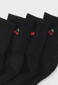 Mustad sokid soonilise tekstuuriga, tikitud punaste kirsikeste ja südamekujundiga. Neli paari, millel graafilised elemendid on erinevalt paigutatud.