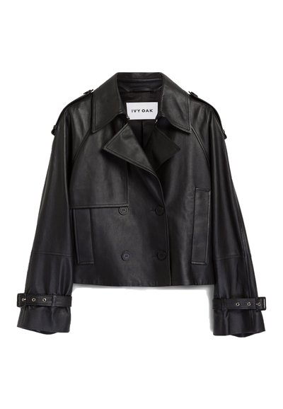 Giacca corta in pelle nera con design doppiopetto, ampie rever, tasche laterali e dettagli in cintura sulle maniche. Etichetta del marchio visibile.