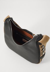 Borsa in pelle nera con forma arrotondata, caratterizzata da una chiusura con zip e dettagli in tessuto beige. L'interno presenta una tasca con zip e una foderatura liscia.