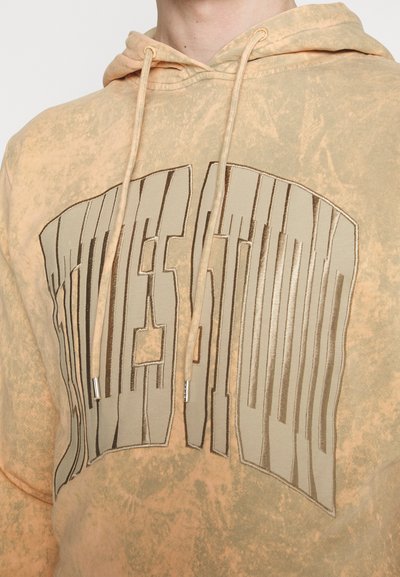 Μπεζ φούτερ με υφαντή σχεδίαση, που διαθέτει ένα μεγάλο καφέ εκτυπωμένο γραφικό στο στήθος. Συμπεριλαμβάνει σπάγκους και μεταλλικές άκρες.