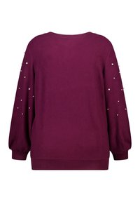 Bordeaux trui met een ronde hals en lange mouwen, voorzien van parelaccenten op de schouders. Zachte stof, geribbelde zoom en manchetten.