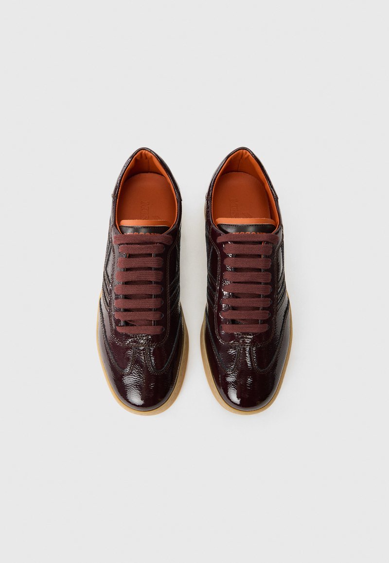 Bordeaux patentlæder sneakers med en tekstureret overflade, rund tå og matchende snørebånd. Udstyret med en gummigummisål og orange for.
