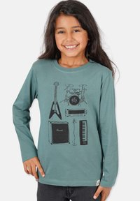 Langærmet t-shirt i teal med sorte grafiske illustrationer af musikinstrumenter: guitar, trommesæt, forstærker og keyboard.