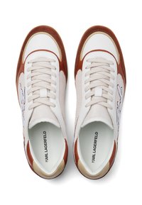 Fehér és barna sportcipők, amelyek hálós és bőr anyagból készültek, lekerekített orral, párnázott gallérral és logódísszel az oldalon.