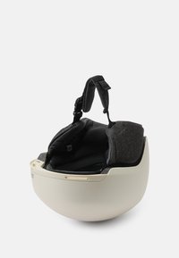 Valge kiiver ümarate joontega, millel on must pehme sisu ja reguleeritavad rihmad sobivuse tagamiseks. Sile pind, kaasaegne konstruktsioon.