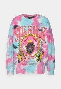 Farverig tie-dye sweatshirt i pink og blå. Har et grafisk print med ornamenteret skjold, guld- og sorte accenter samt ribbede manchetter.