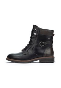Bottine en cuir noir avec lacets à l'avant, bout rond et accents marron. Dotée d'une boucle sur le côté et d'une finition texturée. Talon bas empilé.