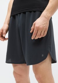 Pantaloni scurți sport pentru bărbați, realizați dintr-un material negru respirabil. Au o textură perforată și un logo brodat pe partea inferioară.