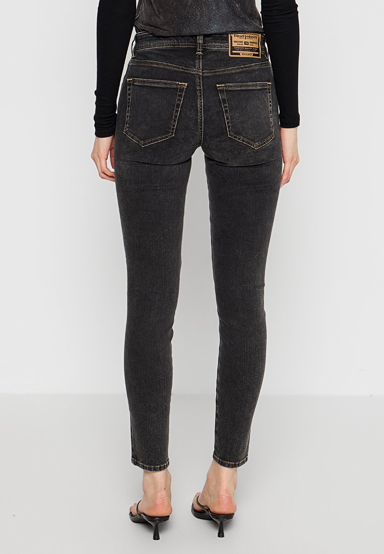 Jeans skinny in denim grigio scuro con una trama liscia, vita media, cuciture visibili e due tasche posteriori con etichetta del logo.