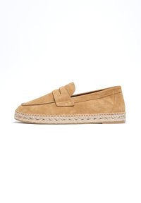 Zapatos de ante tipo slip-on en color marrón con una suela de esparto cosida. Presentan una puntera redondeada y una correa decorativa en la parte superior para un detalle adicional.