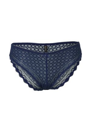 Perizoma in pizzo blu navy con motivo a diamante, bordi ondulati e un fiocco decorativo centrale. Etichetta con il nome del marchio visibile.