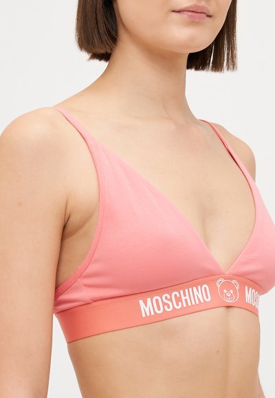 Pink cotton bralette with thin straps and a triangular shape. Features a contrasting elastic band with "MOSCHINO" and a bear logo.