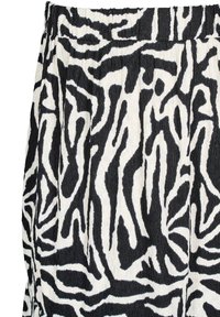 Tissu à motif zébré noir et blanc avec une surface texturée, doté d'une taille élastique froncée et de plis fluides.