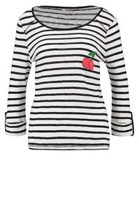 Pasiasty, długi rękaw w białym i czarnym kolorze z okrągłym dekoltem; posiada grafikę wiśni na lewej piersi oraz podwijane rękawy.