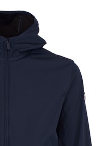 Marineblauw softshelljack met capuchon, ritssluiting aan de voorkant en logo op de bovenarm, getoond van borst tot schouder.