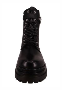 Bota de tobillo de cuero negro con suela gruesa, cordones y cremallera lateral. Cuenta con una correa con hebilla metálica y ojales. Textura lisa.