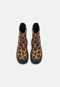 Bottines à imprimé léopard avec une semelle en caoutchouc noir, dotées d'une fermeture éclair et d'un dessus en tissu texturé.