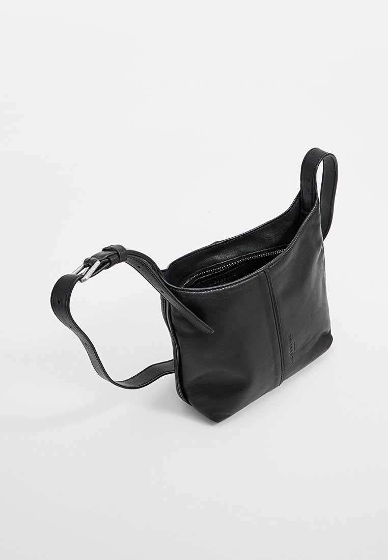 Schwarze Leder-Crossbody-Tasche mit verstellbarem Riemen, gesichertem Hauptfach und glatter Textur auf einem weißen Hintergrund.