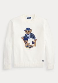 Λευκό πλεκτό πουλόβερ με κεντημένη στη μέση μπροστά αρκουδάκι που φορά μπλε καπέλο και σακάκι και κάθεται σε καρέκλα.