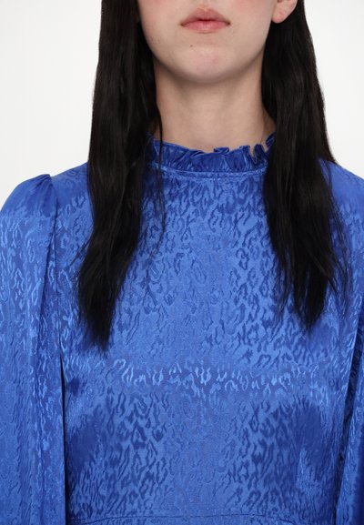 Mėlyna suknelė iš tekstūruotos medžiagos su subtiliu raštu, suklostytu kaklu ir pūstomis rankovėmis. Lygi apdaila ir gyvybinga spalva.