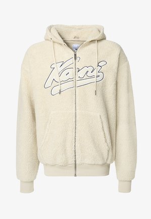 Sudadera de forro polar color crema con cierre de cremallera, bolsillos tipo canguro y capucha con cordón. Logotipo distintivo "Kani" en azul en la parte frontal.