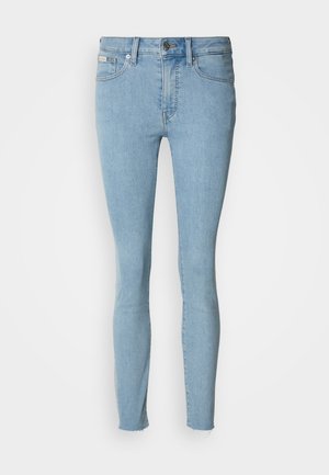 Light blue skinny jeans made of denim. Features a high waist, five-pocket design, and slight fraying at the hem.