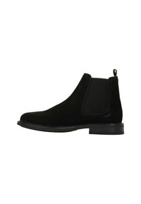 Zwarte suède Chelsea-boots met elastische zijkanten, ronde neus en een treklus op de hiel. Platte rubberen zool, minimalistisch ontwerp.