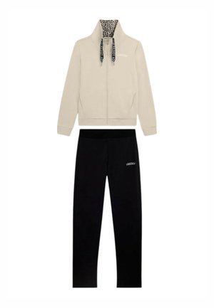 Giacca beige con zip con colletto interno a stampa leopardata e coulisse nere abbinata a pantaloni neri, entrambi con il logo Freddy.