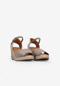 Beige suede wedge sandals with open toe, ankle strap, and woven jute sole. Features a padded insole for comfort and textured accents.