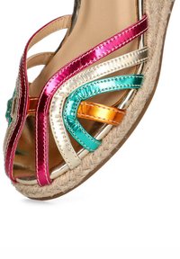Sandalia de cuña multicolor con correas metálicas en rosa, dorado, turquesa y naranja, detalles de yute trenzado y diseño de punta abierta.
