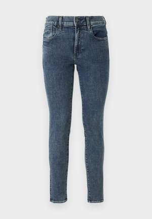 Úzké džíny z tmavě modrého denimu s jemným odřením. Mají středně vysoký pas, pět kapes a kontrastní šití podél švů.