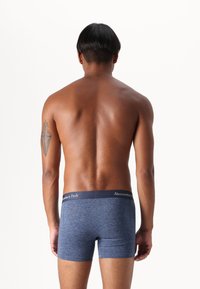 Navy blue boxer shorts with a smooth texture and a branded elastic waistband, viewed from the back on a neutral background.