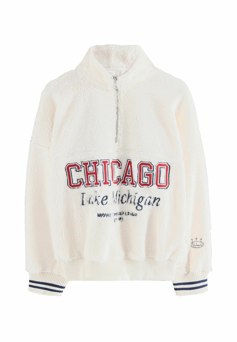 Krém színű fleece pulóver magas gallérral, félig cipzárral az elülső részen, és kék-vörös "CHICAGO Lake Michigan" hímzéssel. Kötött ujjak tengerészkék csíkokkal.