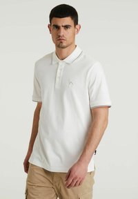 Biely polo tričko s golierom, dvoma gombíkmi na zapínanie a kontrastným lemovaním na rukávoch. Obsahuje malé logo na hrudi. Bavlnený materiál.