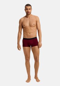 Boxer briefs da uomo bordeaux con cintura elastica nera, realizzati in tessuto liscio, design aderente e lunghezza della gamba corta.