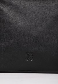 Black leather bag featuring a textured surface and an embossed floral logo at the bottom center. Minimalist design with no visible hardware.