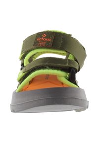 Sandalia de tela verde con correas negras y de neón amarillo. Cuenta con cierres de Velcro ajustables, una plantilla naranja y una suela de goma gris duradera.