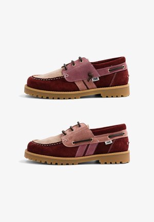 Paire de chaussures bateau en daim bordeaux, rose et beige avec lacets marron, semelles en caoutchouc et étiquettes de marque "Caval" sur les côtés sur fond blanc.