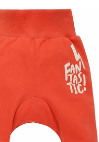 Oranje katoenen sweatpants met een geribde tailleband. Voorzien van witte tekst "FANTASTISCH!" en een bliksemschichtontwerp. Zachte textuur.