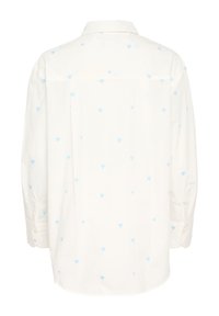 White shirt with light blue heart patterns, long sleeves, and a button-up front. Features a classic collar and a curved hemline.