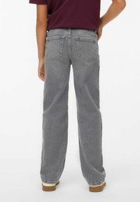 Jeans en denim gris avec une coupe décontractée, dotés de poches arrière et d'un design droit. Fini avec un léger dégradé et un ourlet retroussé.